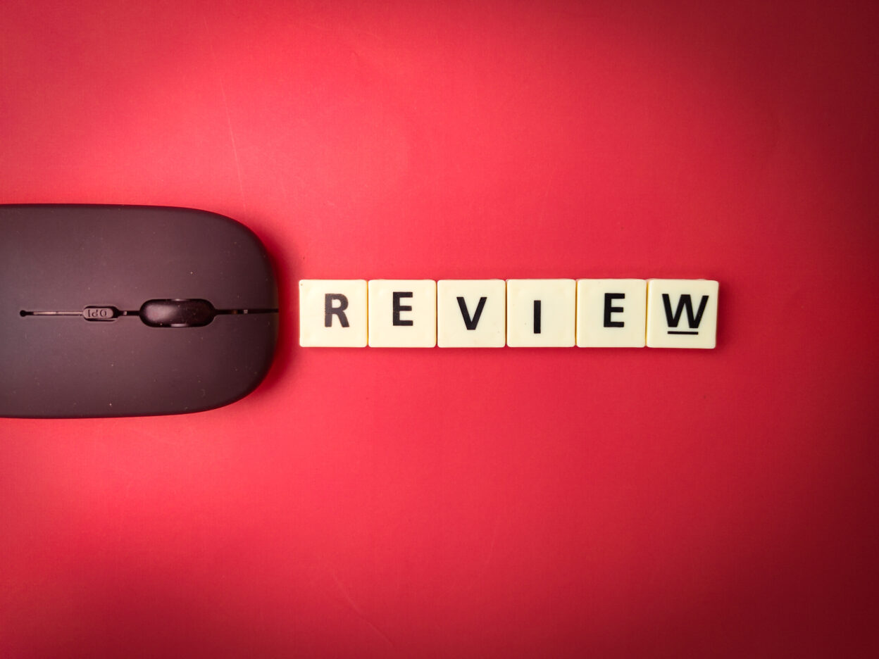 BambooHR review concept with a wireless mouse and the word "review" spelled out in letter tiles on a red background.
