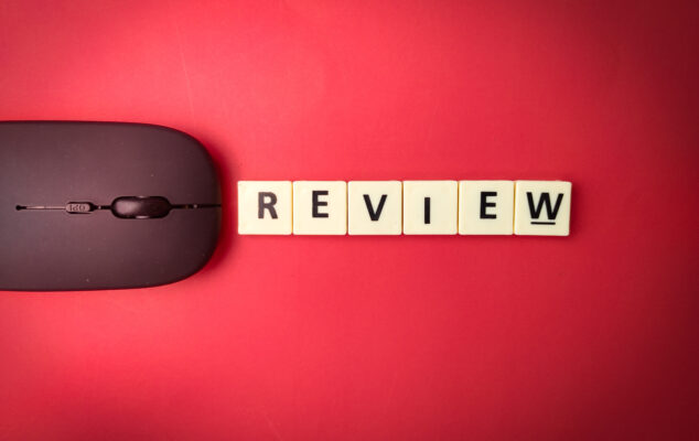 BambooHR review concept with a wireless mouse and the word "review" spelled out in letter tiles on a red background.
