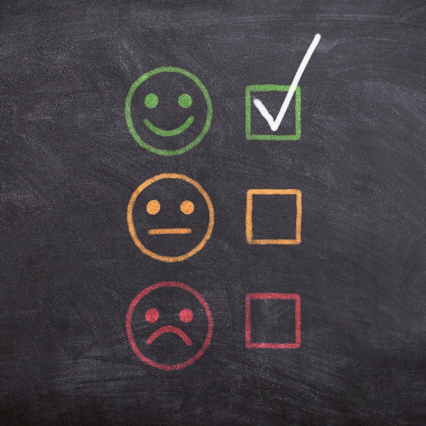 Illustration of performance review feedback with smiley, neutral, and sad faces used to represent employee evaluations.