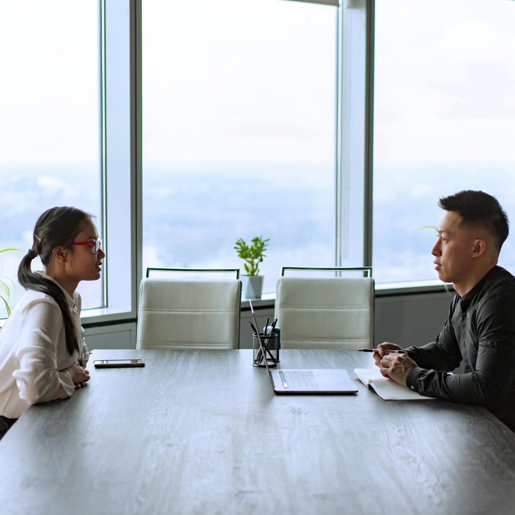 Manager holding regular check-ins with employees to discuss goals and feedback in a modern office.