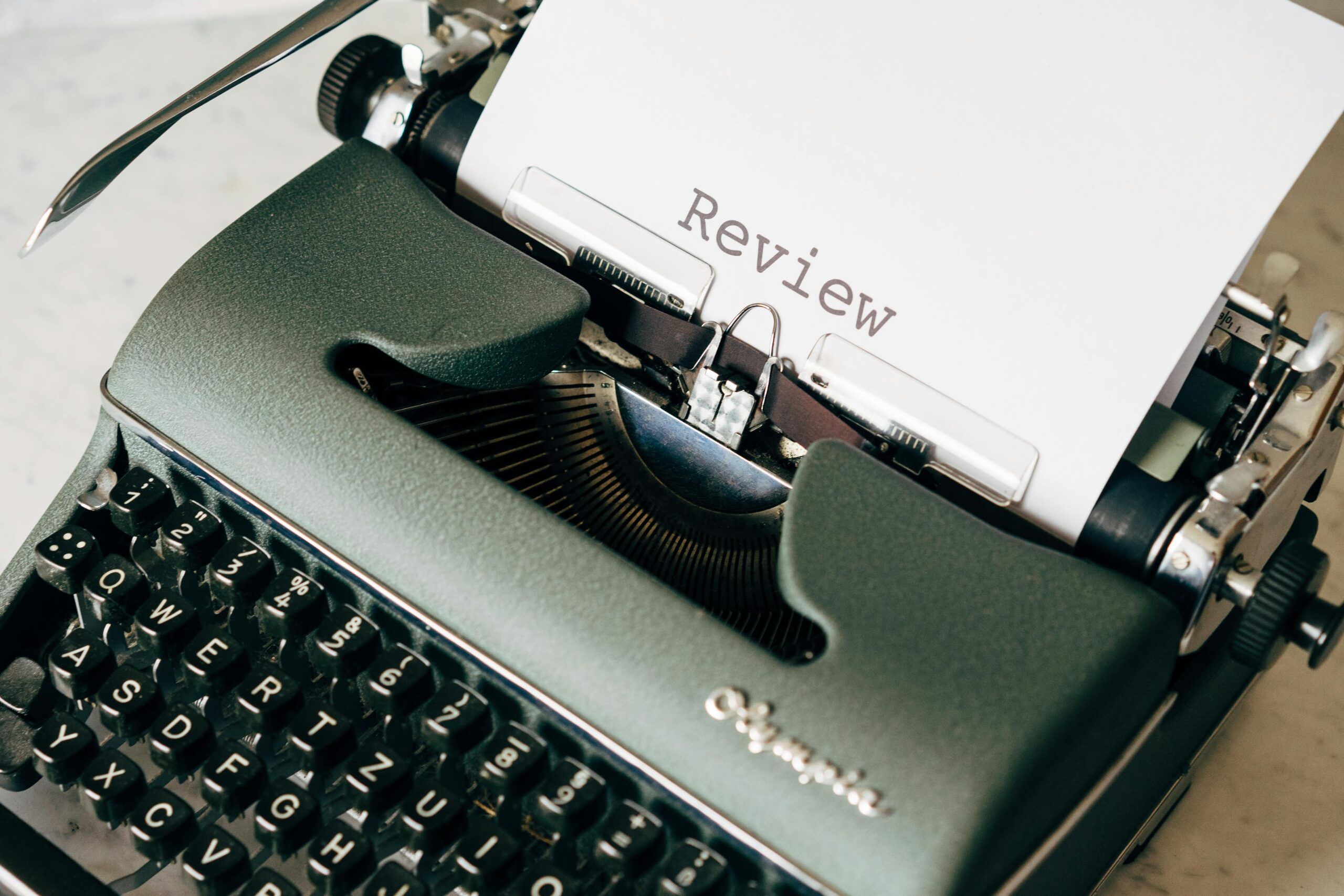 Typewriter with a paper titled "Review" representing Zoho People review
