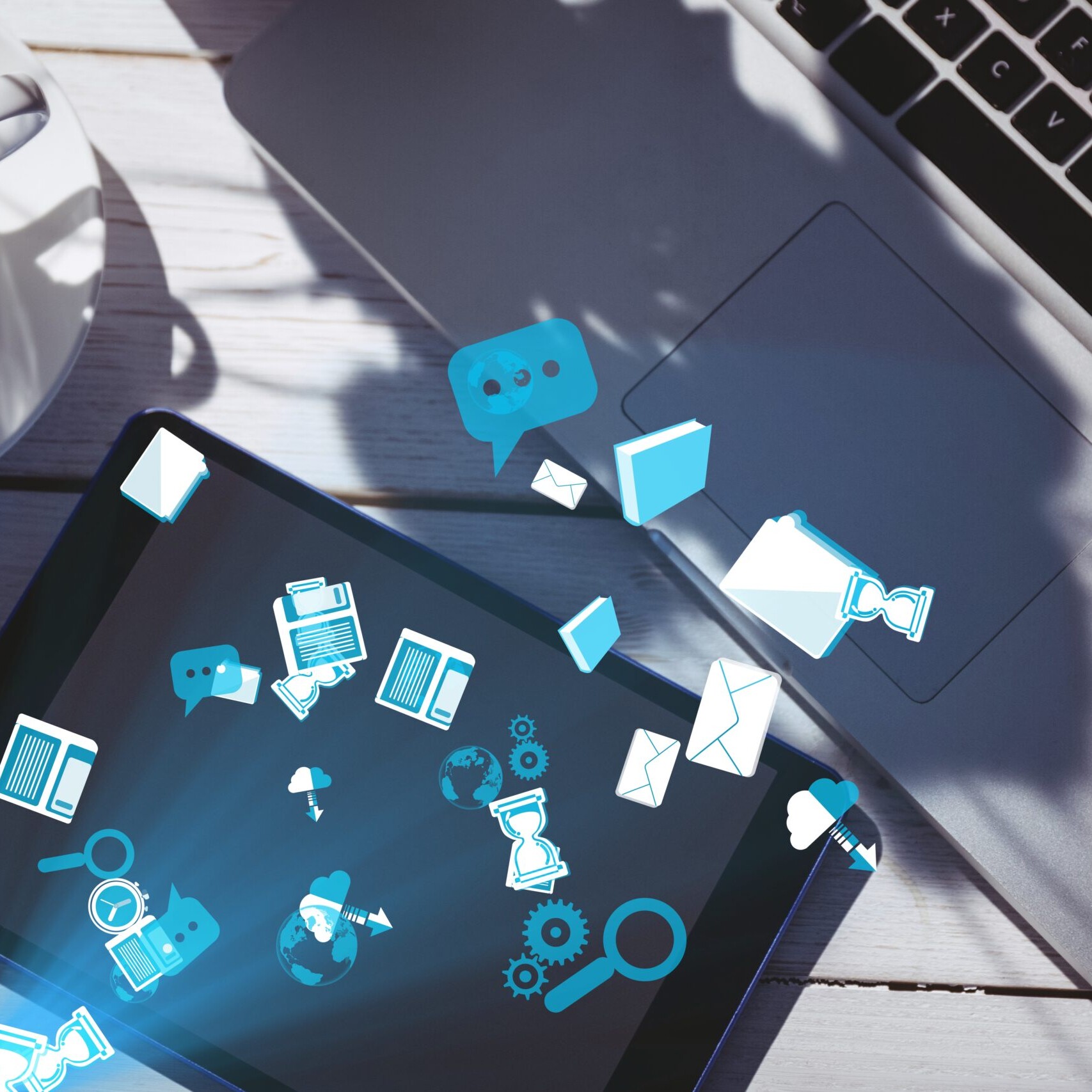 Internal communication software illustrated with digital icons flowing between a laptop and tablet on a desk.