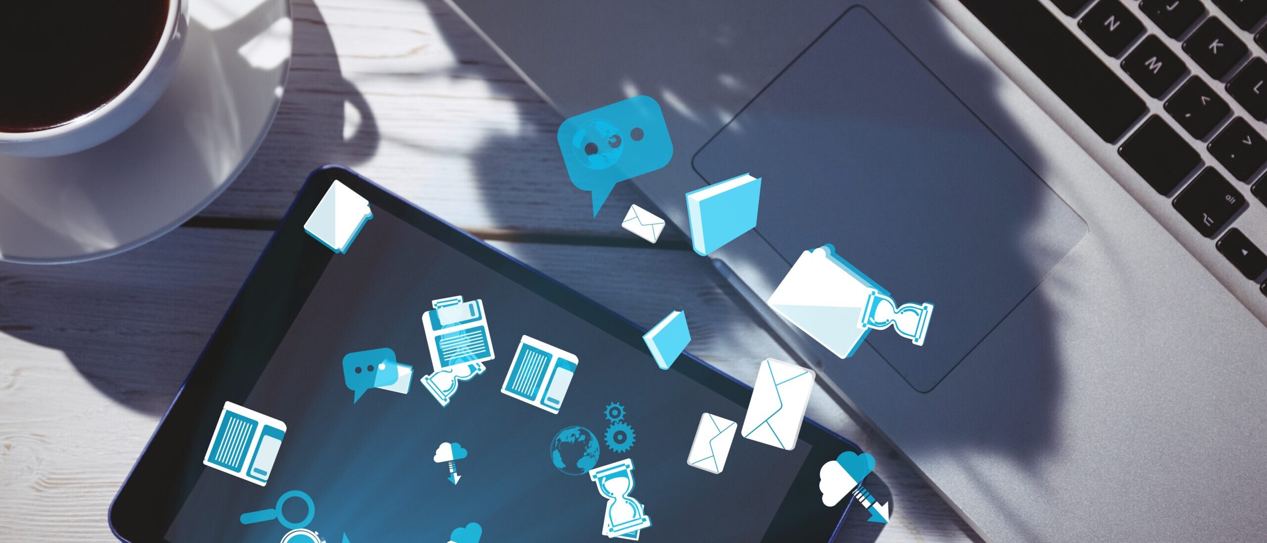 Internal communication software illustrated with digital icons flowing between a laptop and tablet on a desk.