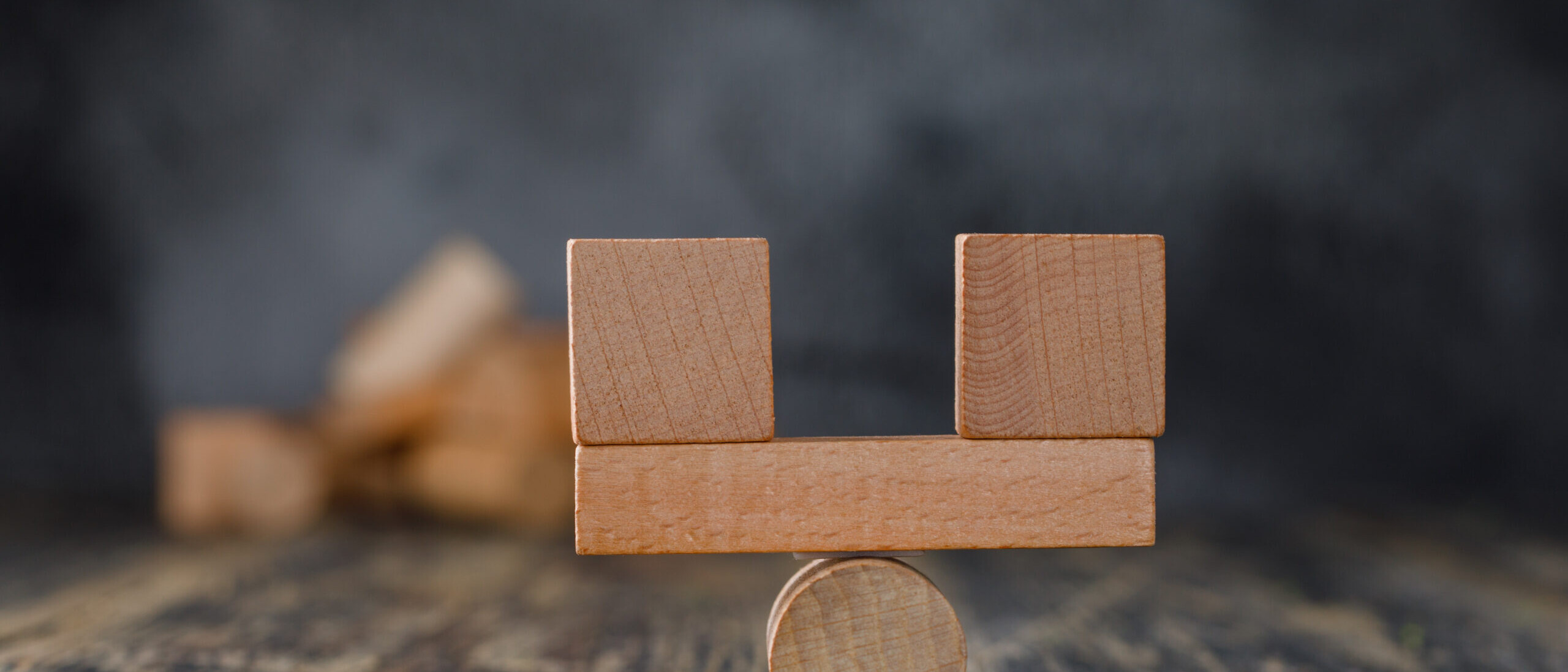 Deel vs Rippling comparison concept with balanced wooden blocks on a scale